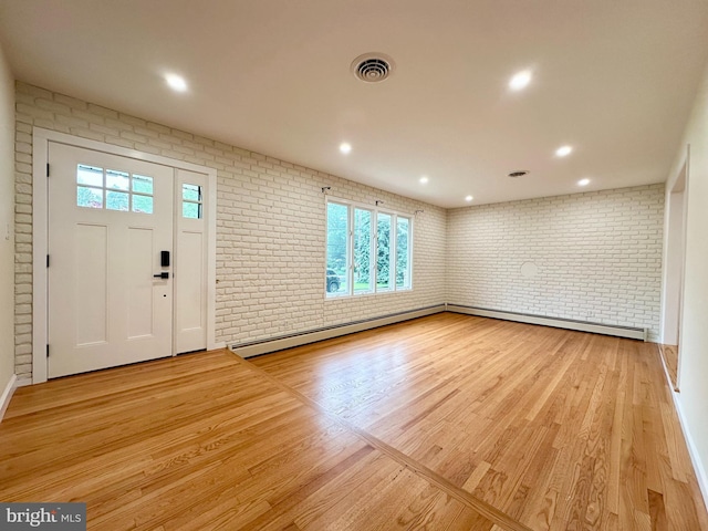 entryway with brick wall, wood finished floors, a baseboard heating unit, recessed lighting, and baseboards