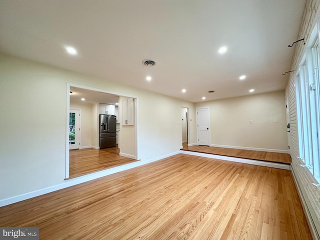 spare room featuring baseboards, light wood finished floors, and recessed lighting