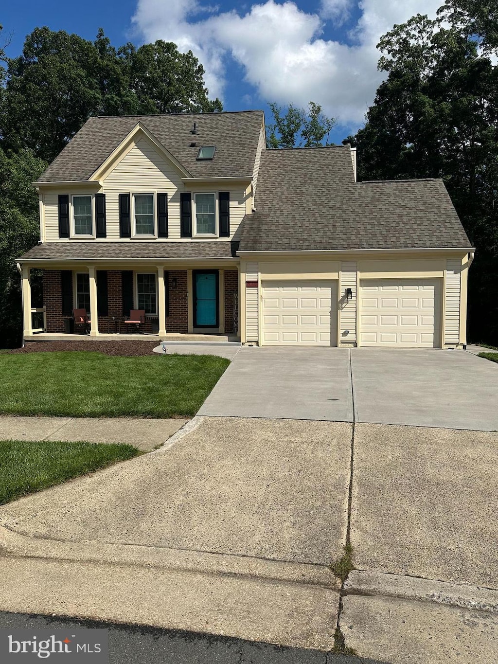 view of front of house with an attached garage, concrete driveway, covered porch, and a shingled roof
