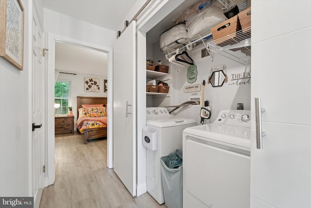 1702 Stoneham Dr, West Chester, PA 19382 - laundry room with washer and dryer, light wood-style floors, and a barn door