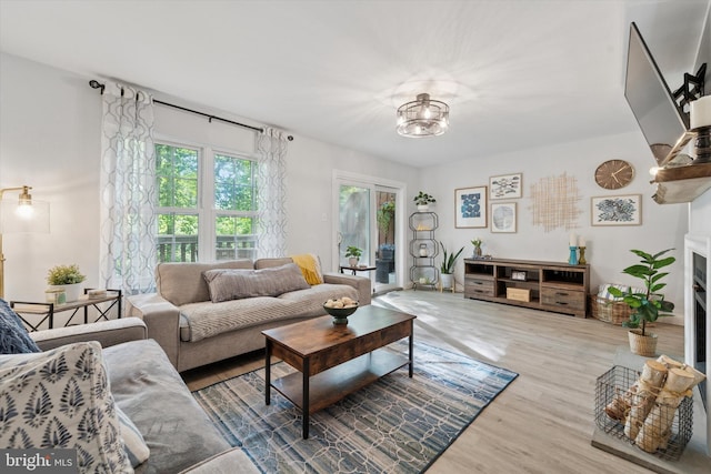 1702 Stoneham Dr, West Chester, PA 19382 - living room featuring wood finished floors, a fireplace, and a chandelier