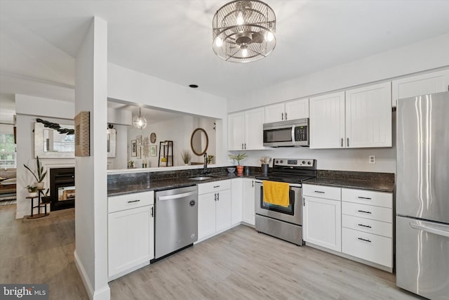 1702 Stoneham Dr, West Chester, PA 19382 - kitchen featuring stainless steel appliances, light wood-type flooring, a sink, and white cabinets