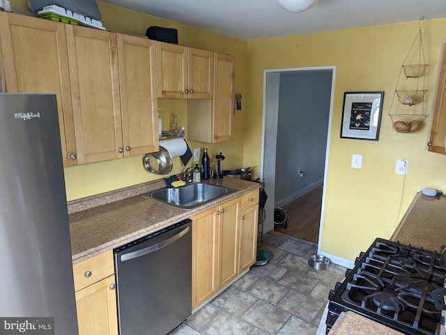 kitchen with stainless steel dishwasher, fridge, a sink, and light brown cabinets
