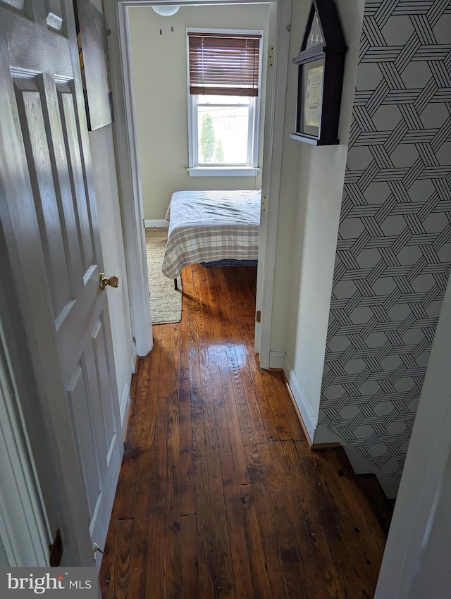 hallway with hardwood / wood-style floors and baseboards