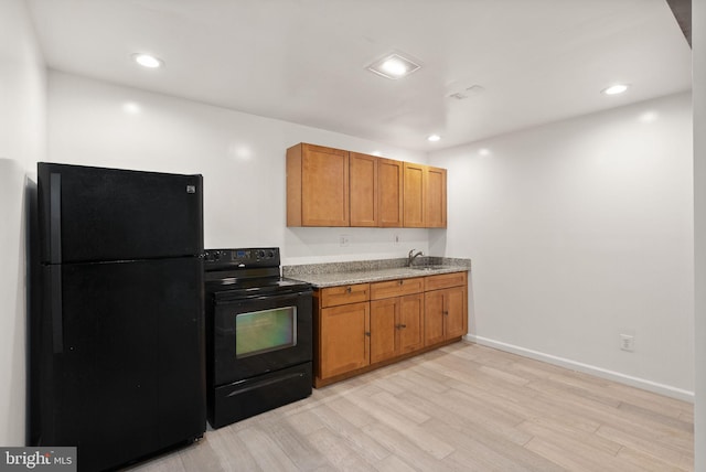 513 Tavenner Ct, Sterling, VA 20164 - kitchen with black appliances, light wood-style floors, brown cabinetry, a sink, and baseboards
