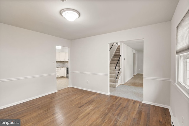 513 Tavenner Ct, Sterling, VA 20164 - empty room featuring wood finished floors, stairway, baseboards, and a baseboard heating unit