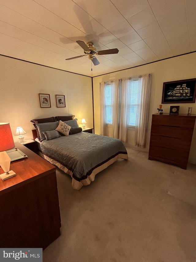 carpeted bedroom featuring ceiling fan and a desk