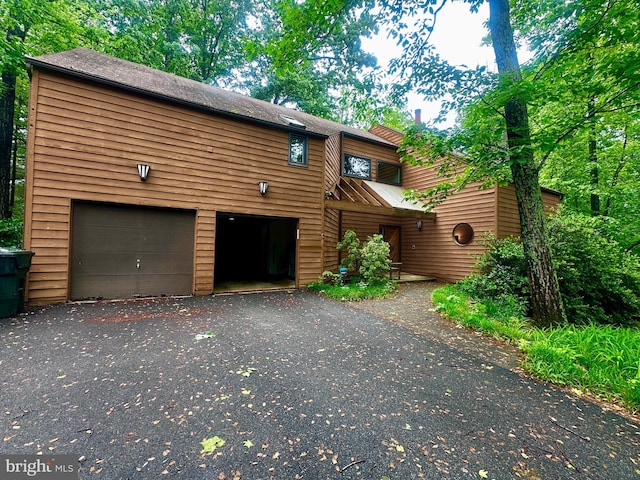 rustic home featuring a garage and driveway