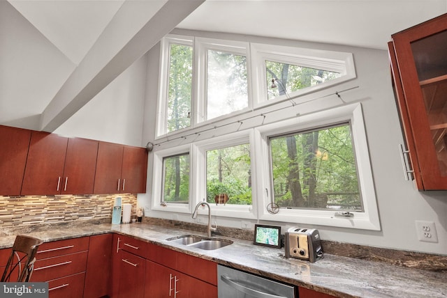 kitchen featuring a sink, dishwasher, light stone countertops, and tasteful backsplash