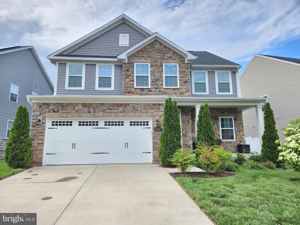 craftsman-style home with stone siding, concrete driveway, and an attached garage