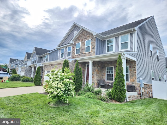 craftsman inspired home with stone siding, a front lawn, concrete driveway, a garage, and a residential view