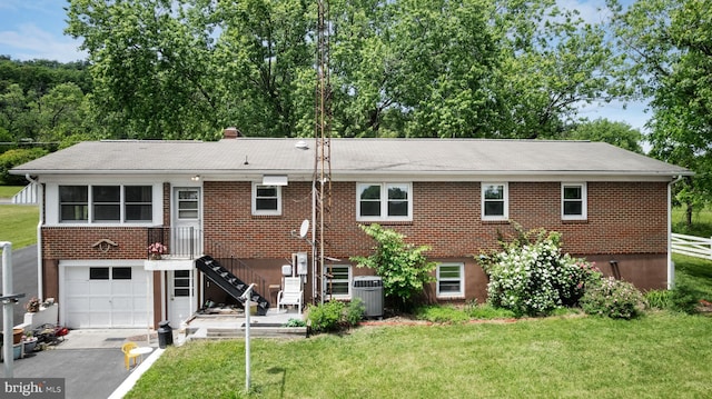 350 Poorhouse Rd, Winchester, VA 22603 - back of house with a yard, a garage, cooling unit, asphalt driveway, and brick siding