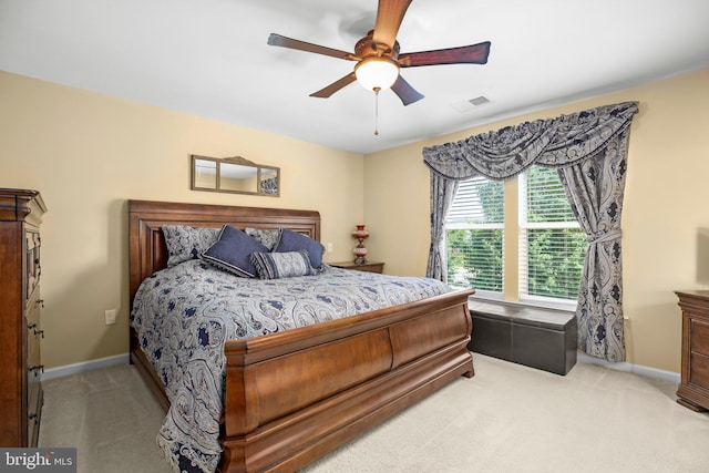 bedroom with light colored carpet, baseboards, and ceiling fan