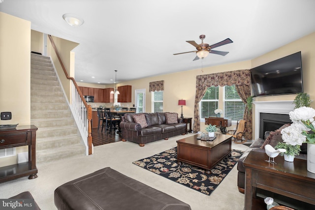 living area featuring stairway, ceiling fan, a fireplace, recessed lighting, and carpet flooring