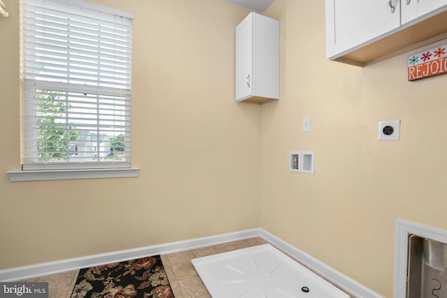 laundry area with electric dryer hookup, washer hookup, baseboards, cabinet space, and tile patterned floors