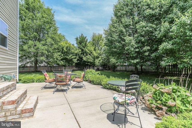 view of patio / terrace with outdoor dining space and view of scattered trees