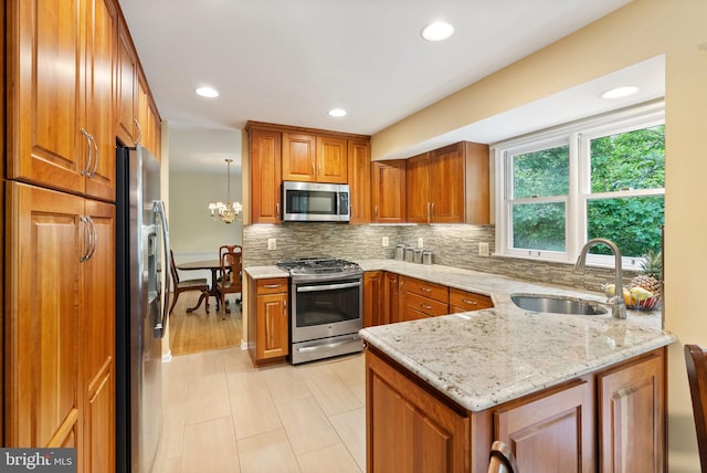 5212 Braywood Dr, Centreville, VA 20120 - kitchen featuring appliances with stainless steel finishes, a sink, brown cabinets, backsplash, and light stone countertops