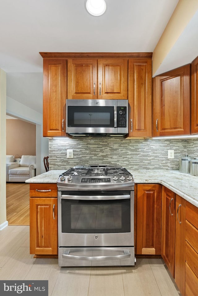 5212 Braywood Dr, Centreville, VA 20120 - kitchen featuring stainless steel appliances, brown cabinetry, and tasteful backsplash
