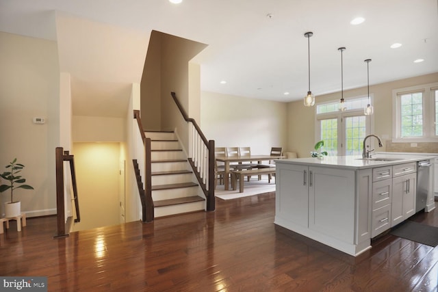 kitchen with a sink, dark wood-style floors, light countertops, recessed lighting, and pendant lighting