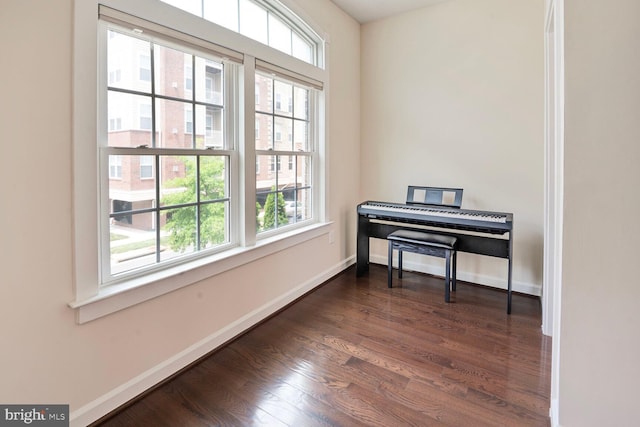 sitting room featuring plenty of natural light, dark wood-style floors, and baseboards