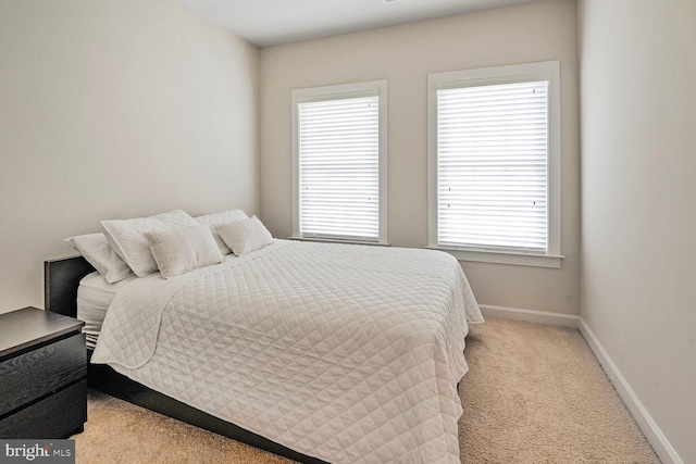 bedroom featuring multiple windows, carpet flooring, and baseboards