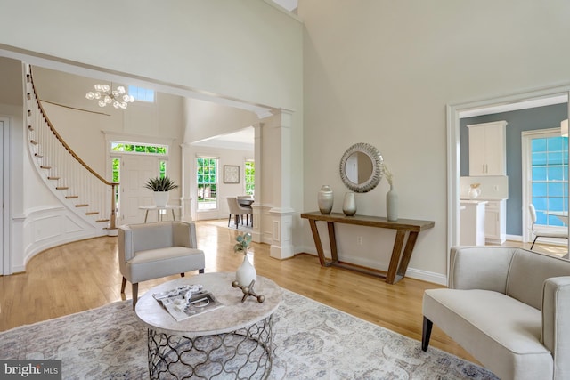 5252 Winter View Dr, Alexandria, VA 22312 - living area with a towering ceiling, light wood finished floors, stairs, a chandelier, and baseboards