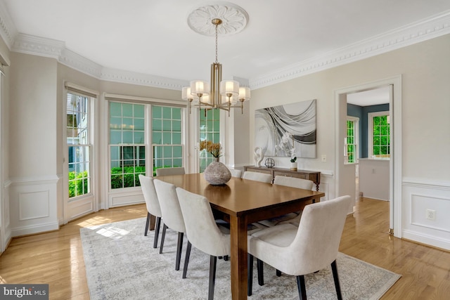 5252 Winter View Dr, Alexandria, VA 22312 - dining space featuring a chandelier, light wood finished floors, crown molding, a decorative wall, and wainscoting