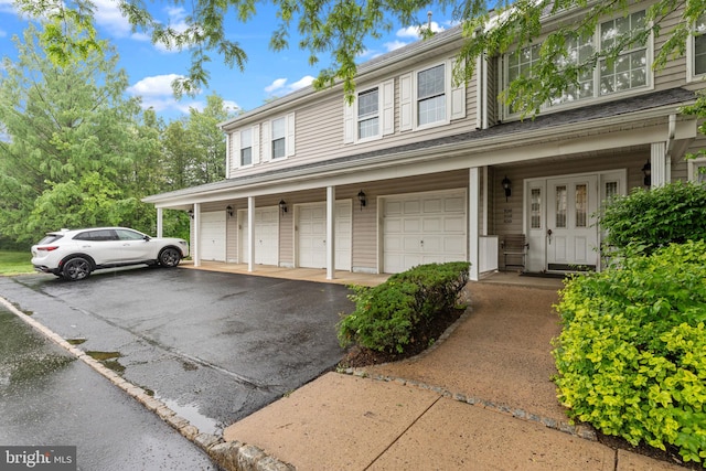 view of property featuring a garage and asphalt driveway