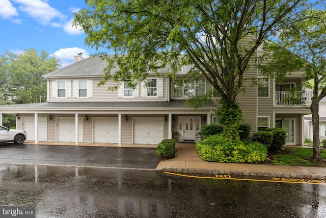 townhome / multi-family property with driveway, an attached garage, and a chimney