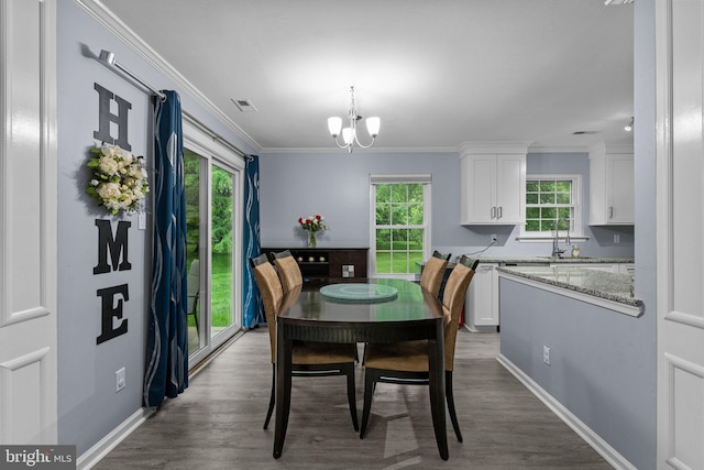dining area featuring ornamental molding, a chandelier, dark wood-style flooring, and baseboards
