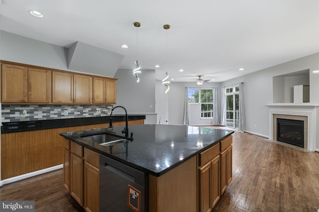 23466 Twin Falls Ter, Brambleton, VA 20148 - kitchen with a sink, dishwasher, decorative backsplash, a glass covered fireplace, and dark wood-type flooring