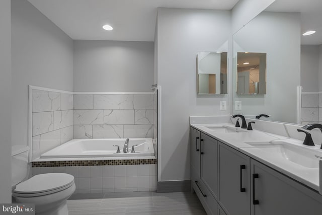 23466 Twin Falls Ter, Brambleton, VA 20148 - bathroom with a garden tub, double vanity, toilet, recessed lighting, and baseboards