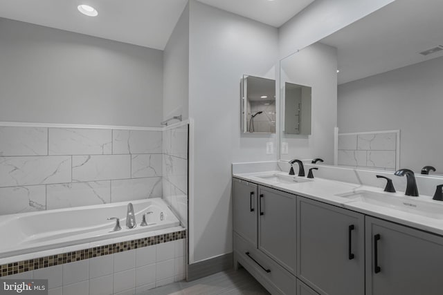 23466 Twin Falls Ter, Brambleton, VA 20148 - bathroom featuring tiled tub, double vanity, and baseboards