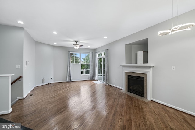 23466 Twin Falls Ter, Brambleton, VA 20148 - unfurnished living room featuring a premium fireplace, wood finished floors, recessed lighting, ceiling fan, and baseboards