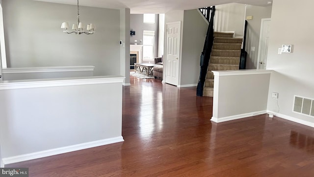 foyer with dark wood-style floors, stairs, baseboards, and a chandelier