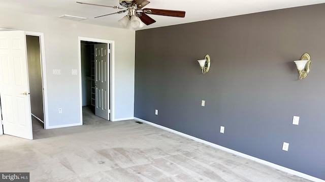 unfurnished bedroom with a spacious closet, baseboards, carpet, a ceiling fan, and a closet