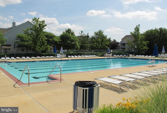 community pool with fence and a patio area