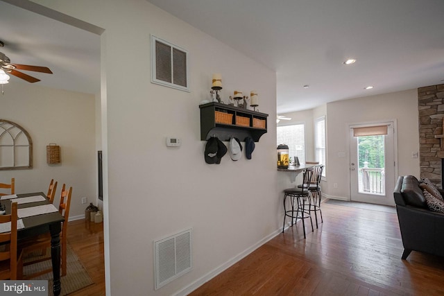 corridor with wood finished floors, baseboards, and recessed lighting