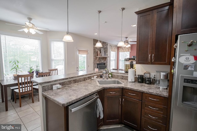 kitchen featuring ceiling fan, stainless steel appliances, a peninsula, a sink, and dark brown cabinets