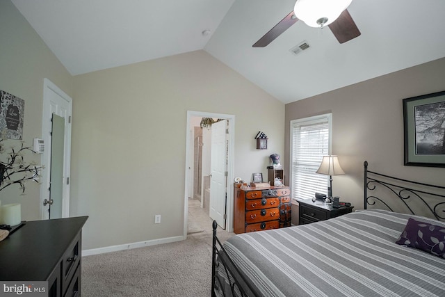 bedroom with vaulted ceiling, light carpet, ceiling fan, ensuite bath, and baseboards