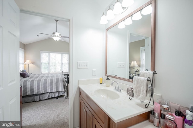 ensuite bathroom with lofted ceiling, ceiling fan, and vanity