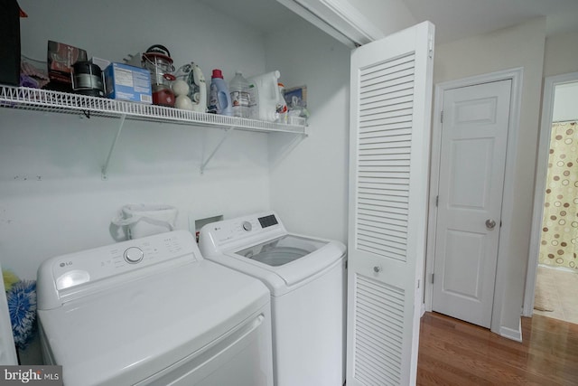 laundry room featuring washer and clothes dryer and wood finished floors