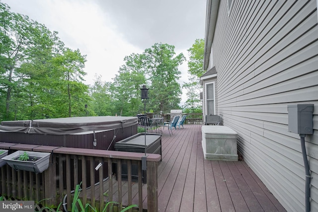 wooden deck with a hot tub and outdoor dining area