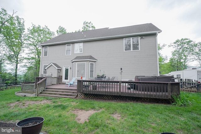 back of house with a hot tub and a deck