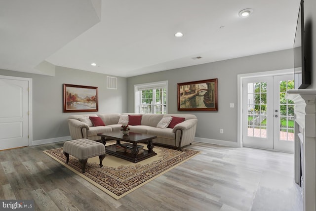 living area featuring baseboards, light wood-style flooring, and recessed lighting