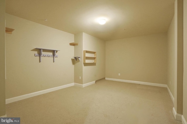 unfurnished room with light colored carpet and baseboards