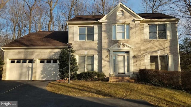 traditional home with driveway, a garage, and brick siding