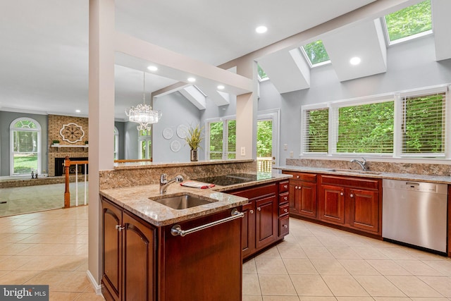 kitchen with dishwasher, a sink, a brick fireplace, light tile patterned floors, and a skylight