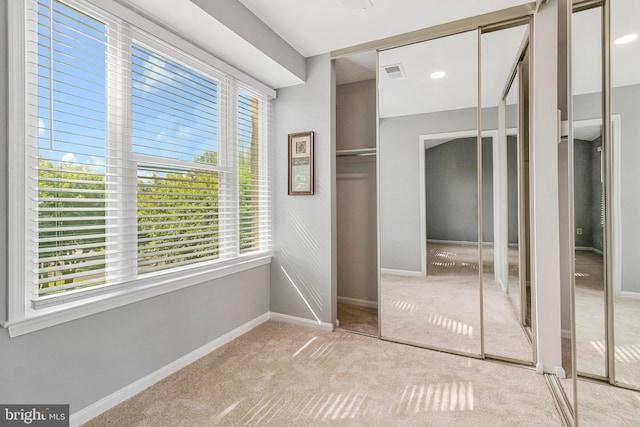 unfurnished bedroom featuring carpet, baseboards, and multiple closets