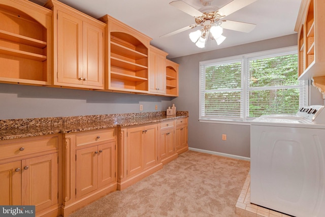 clothes washing area featuring cabinet space, washer and dryer, baseboards, ceiling fan, and light colored carpet